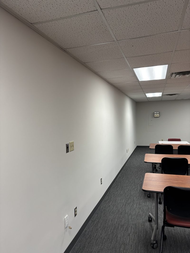 Repainted university classroom with desks and carpet tile flooring